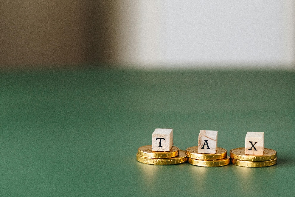 Wooden blocks of the word ‘tax’ placed on gold coins