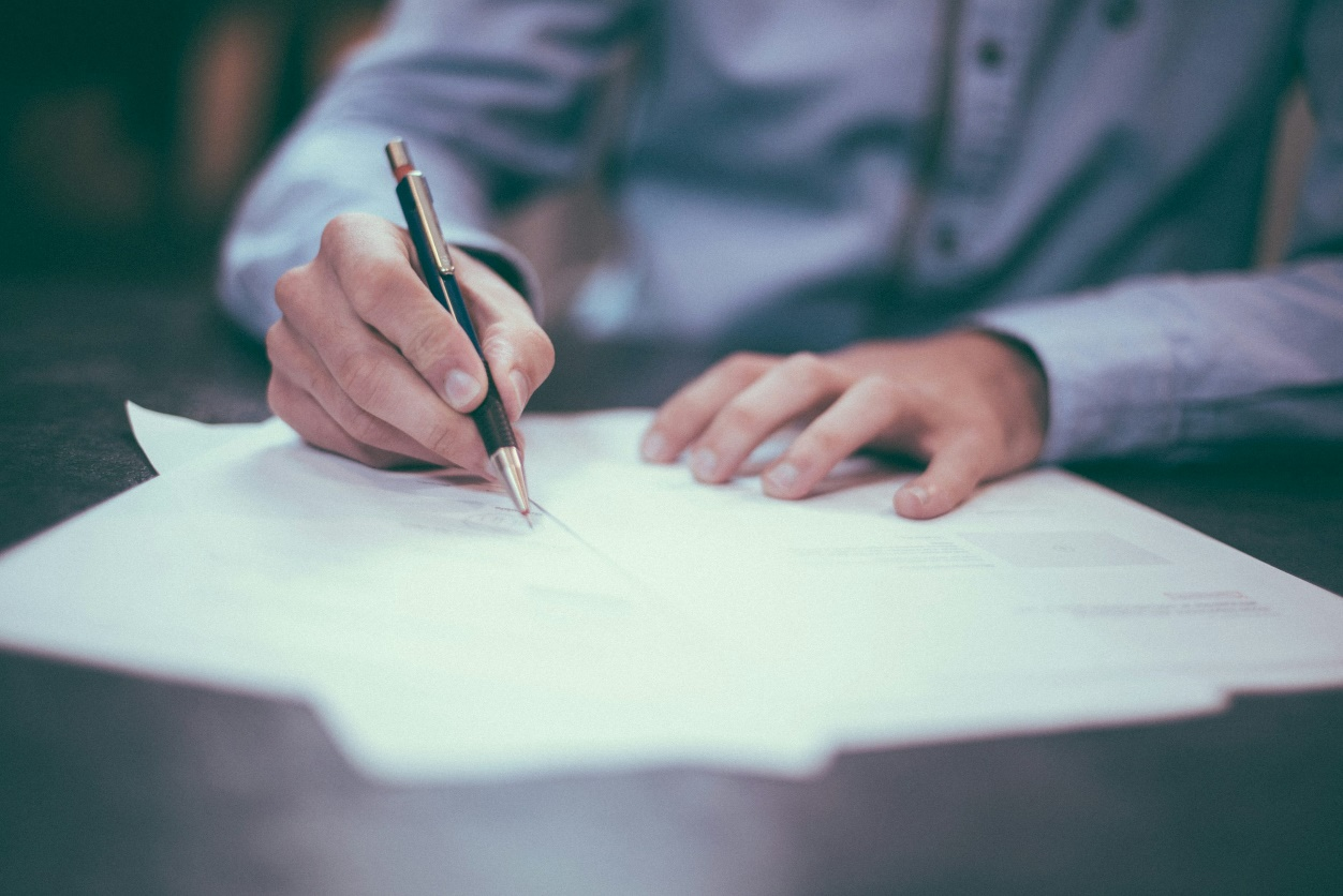 Person reviewing and organizing paperwork for foreign exchange tax reporting.