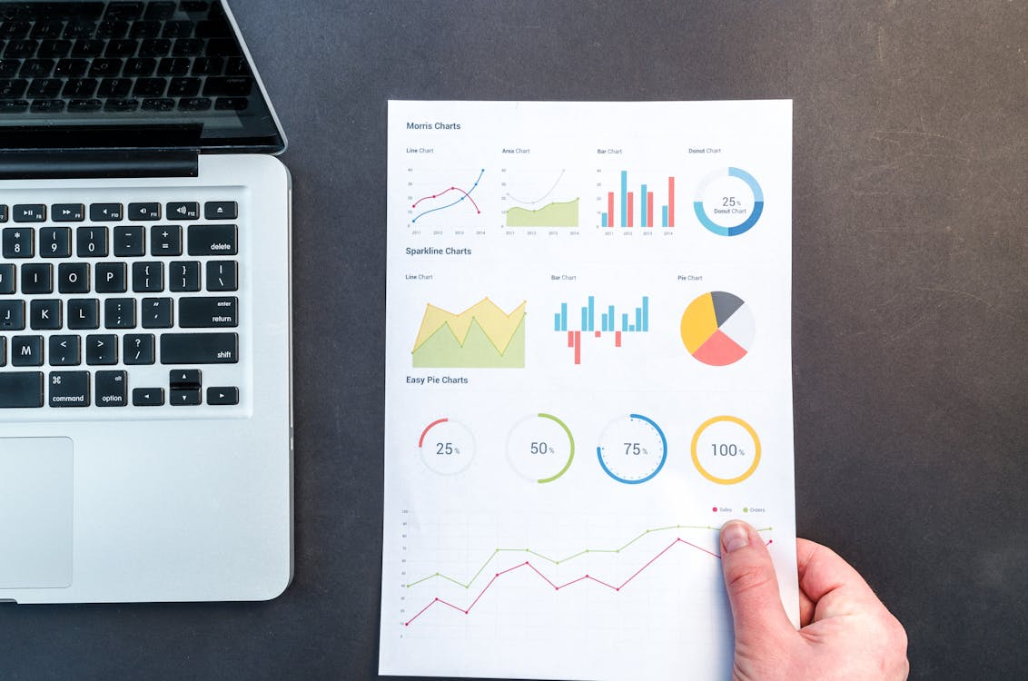 An image of a person holding a paper with data analytics and graphs