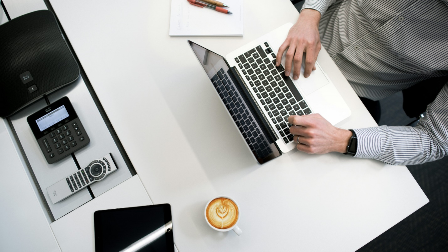 Individual using a laptop to manage corporate tax and foreign exchange reporting tasks.