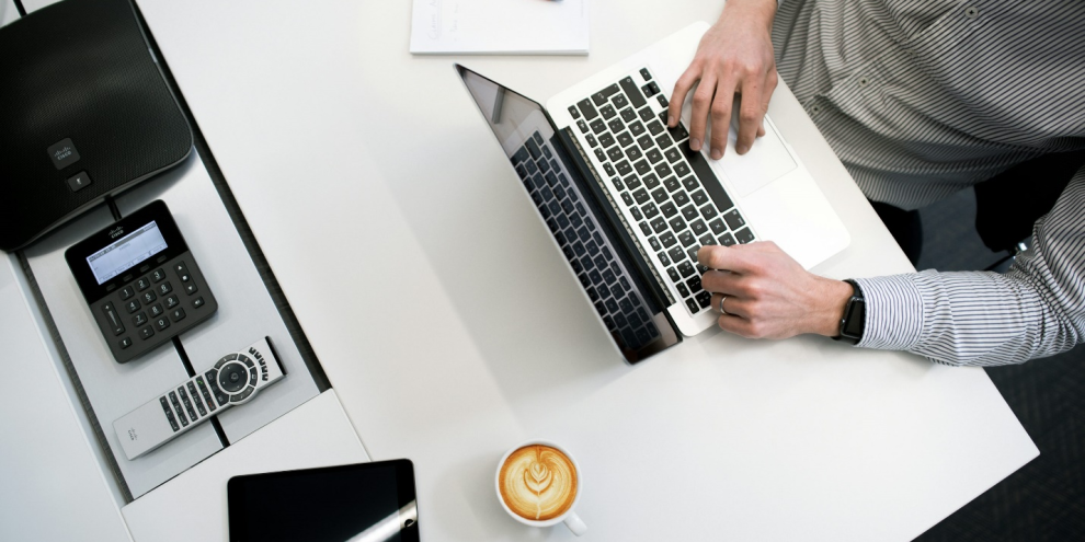 Individual using a laptop to manage corporate tax and foreign exchange reporting tasks.